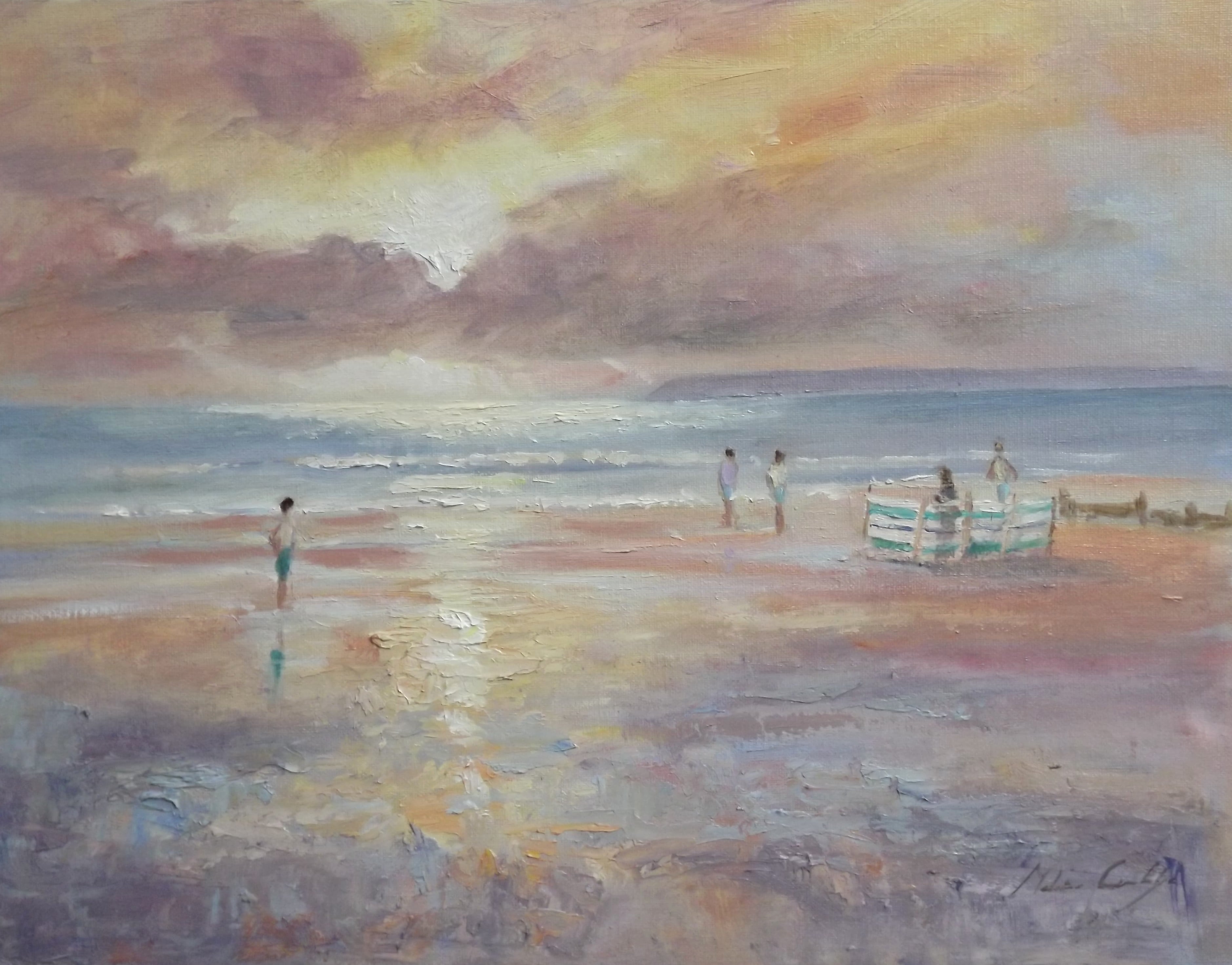 Figures on the beach at West Wittering with backlit windbreak